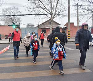 心博(中国)青年文明号义务指挥交通，为学生上学安全保驾护航